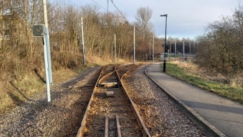A switch where the tramway goes from single to double track. A
                         tram stop is in the background.