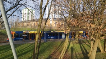 The tram, with houses and two tower blocks in the background.